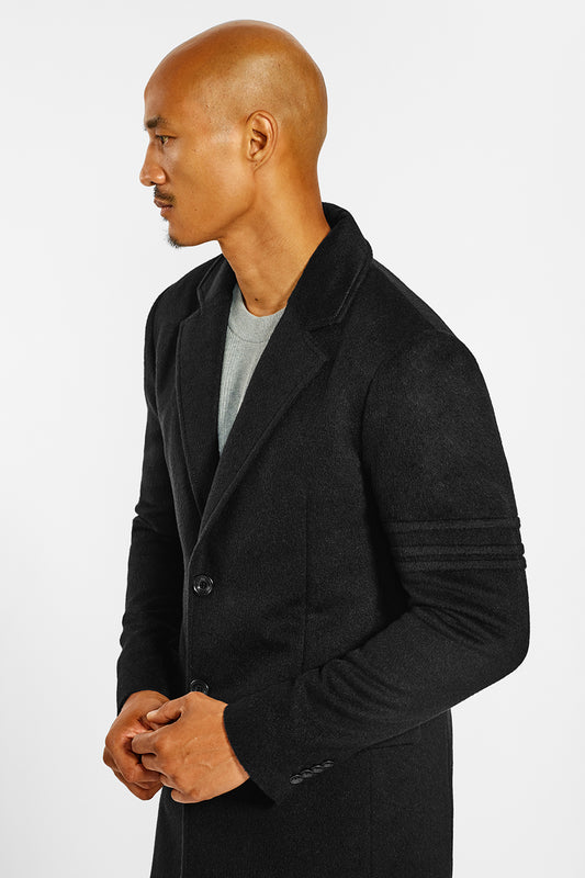 Sentaler Technical Baby Alpaca Notched Lapel Overcoat crafted in Technical Baby Alpaca and available in Black. Seen from side close up on male model.