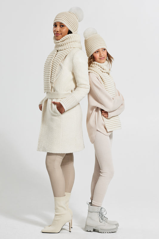 Sentaler Adult and Kids (6-14 Years) Ribbed Hat With Oversized Fur Pompon and Ribbed Scarf featured in Baby Alpaca and available in Ivory. Seen from front on model.