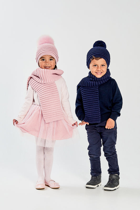 Sentaler Kids (1-5 Years) Ribbed Scarf and Ribbed Hat with Oversized Fur Pompon featured in Baby Alpaca and available in Pink. Seen from front on model.