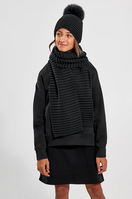 Sentaler Kids (6-14 Years) Ribbed Scarf and Ribbed Scarf featured in Baby Alpaca and available in Black. Seen from front above the knees on model.