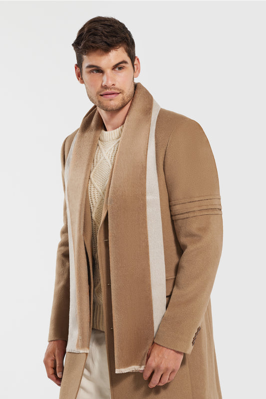 Sentaler Double Sided Suri Alpaca Scarf featured in Suri Alpaca and available in Dark Camel-Light Taupe. Seen from side above the knees on model.